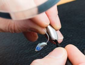 Audiologist repairing hearing aids